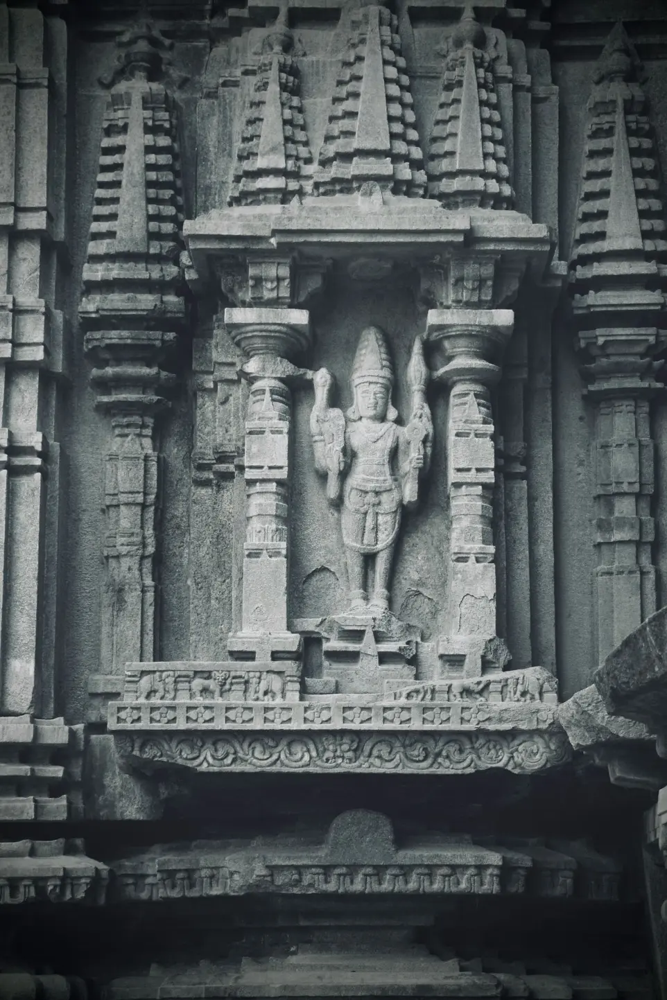 a statue of a man holding a sword in front of a building